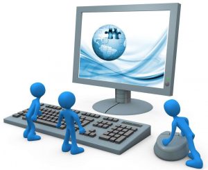 Royalty-free 3d computer generated technology clipart picture image of two tiny blue employees standing in front of a computer keyboard and looking up at a flat screen lcd monitor screen while one person operates the mouse.